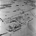 Aerial view of the CERN site in the snow in the 1960s, with the PS accelerator, resembling a bicycle wheel in shape, built on the border between France and Switzerland. The construction of a new machine had led to the extension of the site in France. (Image : CERN)